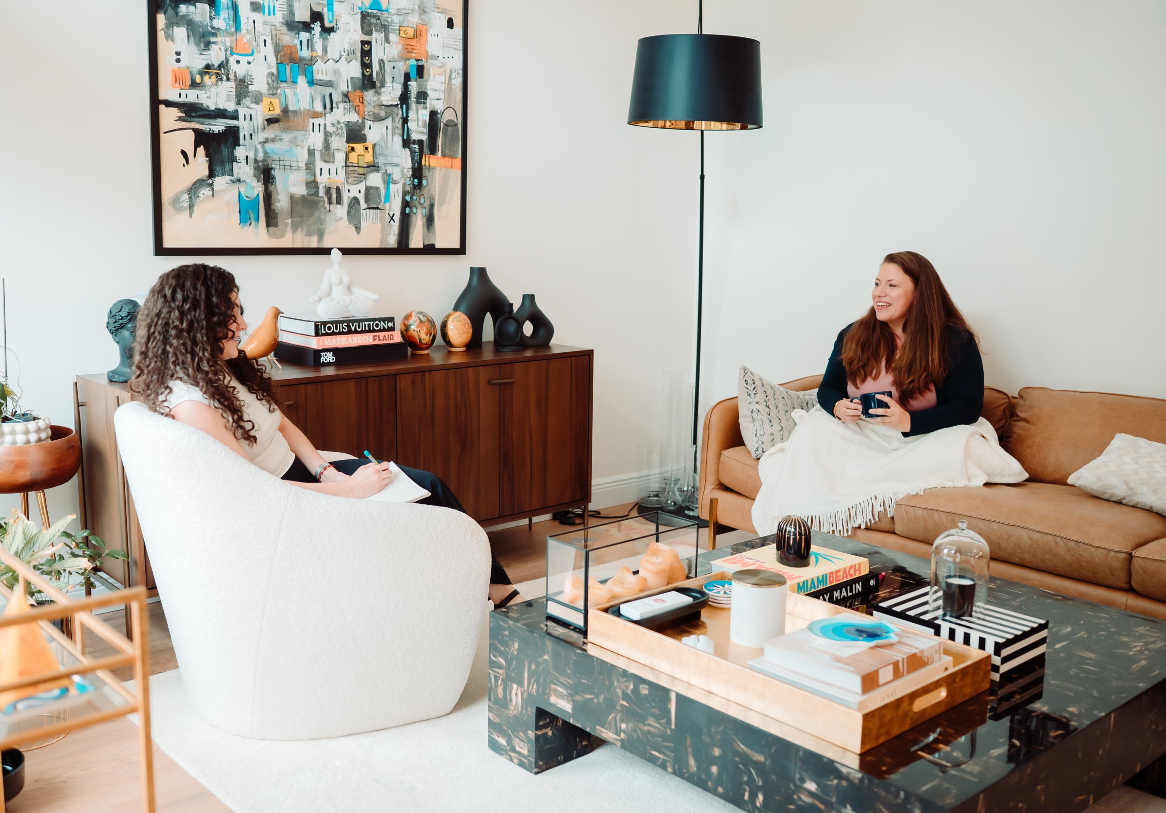 A therapist and client talking in a bright therapy room